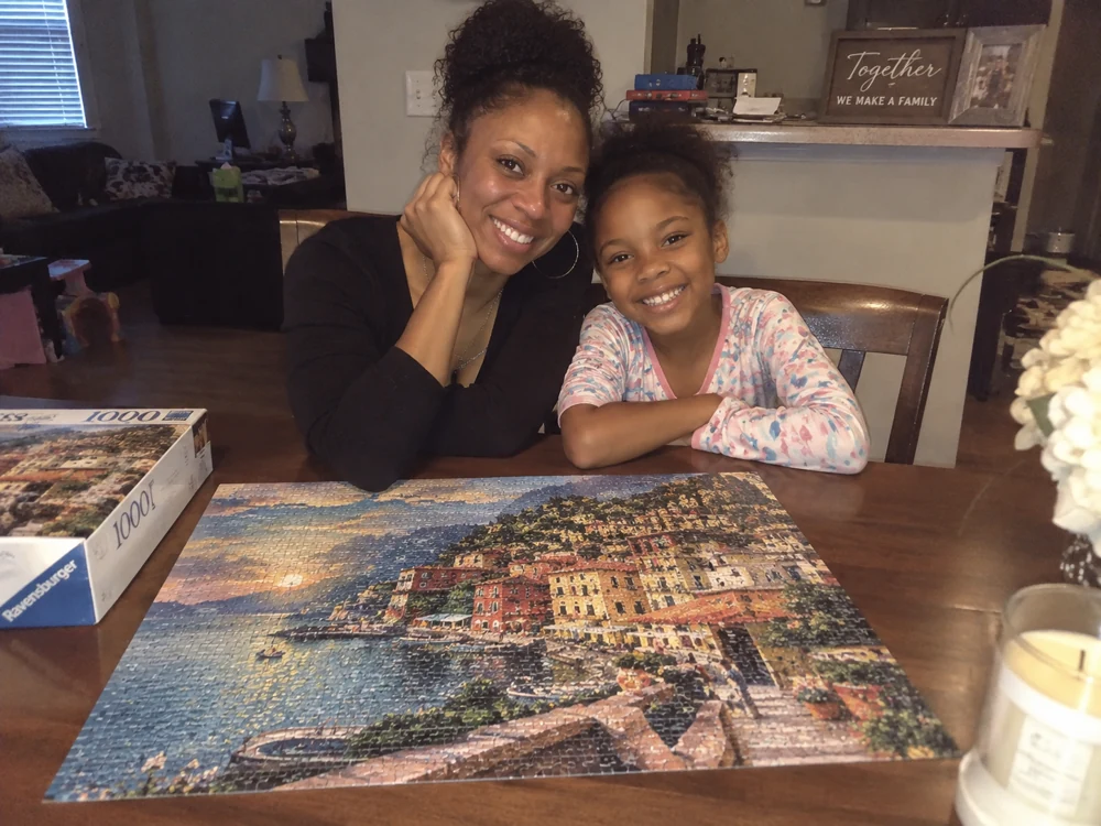 A mother and daughter with their completed puzzle